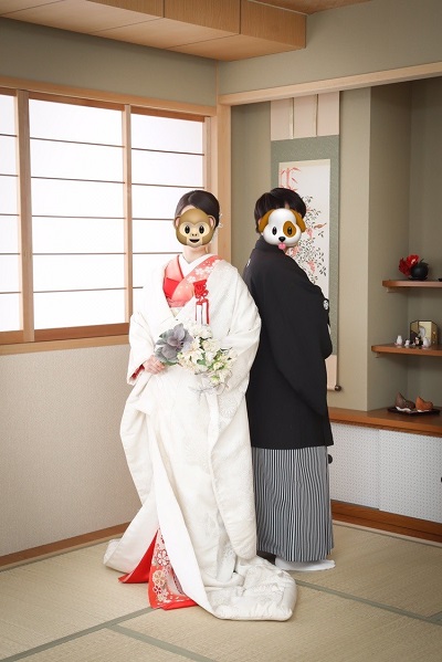 サーモンピンク色のリメイク引き振袖を白無垢の掛下として着た花嫁と花婿