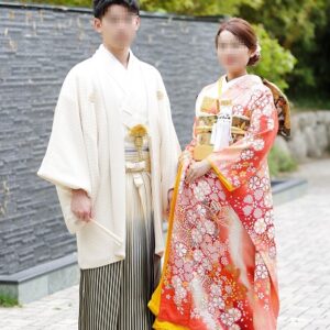 サーモンピンク色のリメイク引き振袖を着た花嫁と花婿