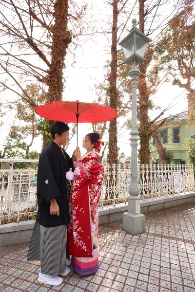 赤色のリメイク打掛を着た花嫁と花婿