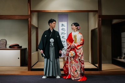 赤色のリメイク打掛を着た花嫁と花婿