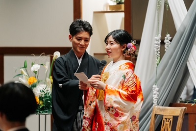 赤色のリメイク打掛を着た花嫁と花婿