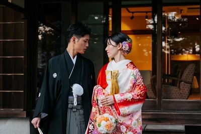 赤色のリメイク打掛を着た花嫁と花婿