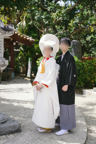 赤色のリメイク引き振袖を掛下として着用し白無垢を着た花嫁と花婿