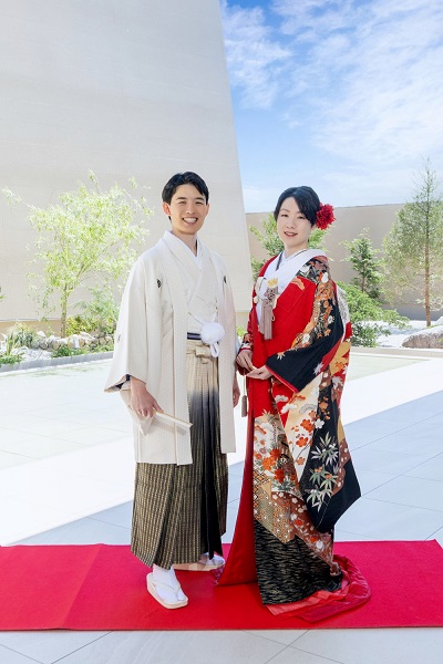 赤色のリメイク打掛を着た花嫁と花婿