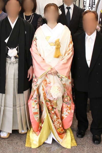 ピンク色のリメイク打掛を着た花嫁と花婿とご親族様